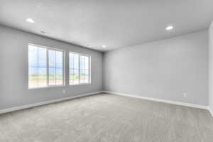 Spare room featuring recessed lighting, carpet, baseboards, and a textured ceiling