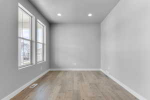 Unfurnished room featuring light wood-style flooring, recessed lighting, and baseboards