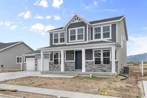 Craftsman inspired home with a porch, concrete driveway, board and batten siding, stone siding, and an attached garage