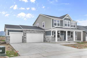 View of front of house featuring board and batten siding, stone siding, and a porch