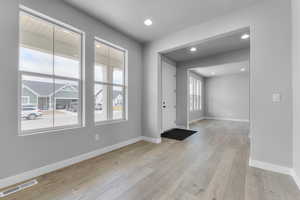 Foyer entrance featuring baseboards, light wood-style floors, and recessed lighting