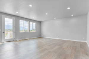 Unfurnished room featuring light wood-style floors, recessed lighting, and baseboards