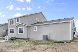Back of house with central air condition unit and stucco siding