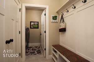 Mudroom featuring washing machine and dryer and light tile patterned floors