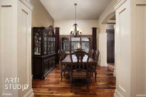 Dining room featuring an inviting chandelier and dark wood-type flooring