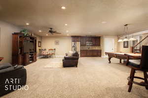 Living room featuring pool table, ceiling fan, light carpet, and a textured ceiling