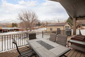 Covered patio/deck with a grill, an outdoor structure, and a mountain view