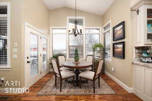 Dining area featuring a notable chandelier, a wealth of natural light, and dark hardwood / wood-style floors