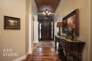 Foyer entrance featuring dark hardwood / wood-style floors and a chandelier