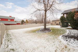 Backyard covered in snow featuring a mountain view and a patio area