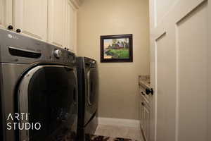 Laundry area featuring cabinets and washer and clothes dryer