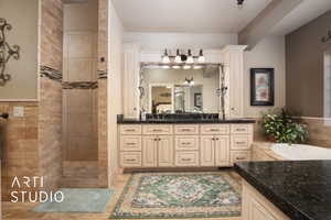 Master Bathroom with vanity, tile patterned flooring, decorative columns, and plus walk in shower