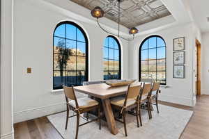 Dining space featuring light hardwood / wood-style floors and a raised ceiling