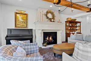 Living room with hardwood / wood-style flooring, a high end fireplace, and beamed ceiling