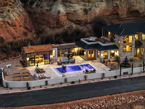 Rear view of house with a patio area, an outdoor living space with a fire pit, and an in ground hot tub