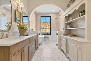 Bathroom featuring brick wall, shower with separate bathtub, vanity, and tile patterned floors