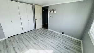 Unfurnished bedroom with light wood-type flooring and a closet