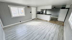 Kitchen with white cabinetry, range, light hardwood / wood-style flooring, white fridge, and ceiling fan