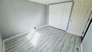 Unfurnished bedroom featuring light hardwood / wood-style floors and a closet