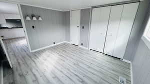 Unfurnished bedroom featuring two closets and light hardwood / wood-style flooring