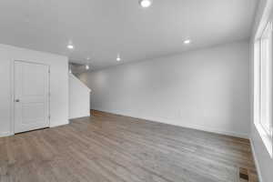 Empty room featuring light wood-type flooring and a textured ceiling