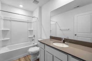 Full bathroom with toilet, vanity, shower / bathing tub combination, and wood-type flooring