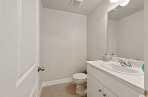 Bathroom featuring vanity, tile patterned flooring, and toilet