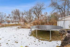 Yard covered in snow with a trampoline