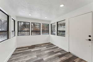 Interior space with dark hardwood / wood-style floors and a textured ceiling