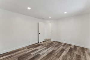 Unfurnished room with dark wood-type flooring and a textured ceiling