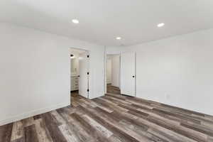 Unfurnished bedroom with dark hardwood / wood-style floors and ensuite bath