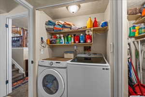 Washroom with washing machine and dryer and carpet flooring