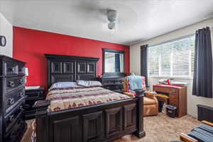 Carpeted bedroom featuring ceiling fan