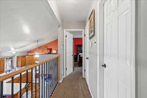 Corridor featuring lofted ceiling and carpet flooring