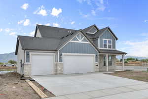 Craftsman-style home with stone siding, a shingled roof, an attached garage, and concrete driveway