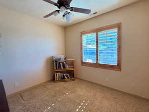 Spare room with ceiling fan, carpet floors, and a textured ceiling