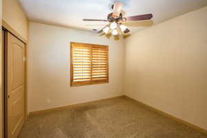 3rd bedroom, carpeted with closet and wood shuttered window.