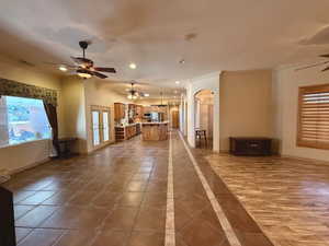 Unfurnished living room featuring ceiling fan