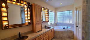 Bathroom featuring vanity and tiled tub