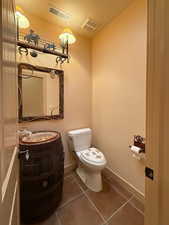 Bathroom featuring tile patterned floors, sink, and toilet