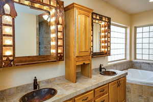 Bathroom with double vanity, large walk-in closet room, private room with bidet toilet. linen closet, walk in tile shower, ceiling fan, tile custom sink and mirrored vanity lights, tile flooring, and jetted garden tub