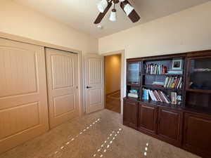 Carpeted home office featuring a textured ceiling and ceiling fan