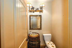 Half bathroom with custom country flair located in hall outside of the office on the owners side of the home.