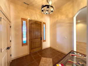 Tiled foyer entrance with a chandelier