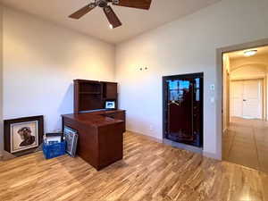 Office with light hardwood / wood-style flooring and ceiling fan