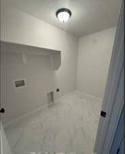 Laundry area featuring hookup for a washing machine, hookup for an electric dryer, and a textured ceiling