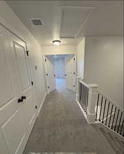 Hallway featuring carpet and a textured ceiling