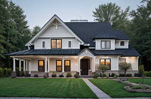 View of front facade featuring covered porch and a front lawn