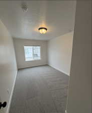 Spare room with carpet flooring and a textured ceiling