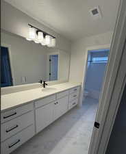 Full bathroom featuring toilet, a textured ceiling, vanity, and tub / shower combination